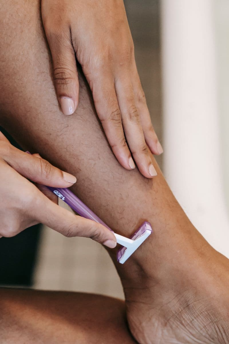 Woman using a razor for dermaplaning skin treatment — dermaplaning aftercare tips for glowing skin